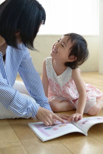 写真　親子で絵本指差しえがお